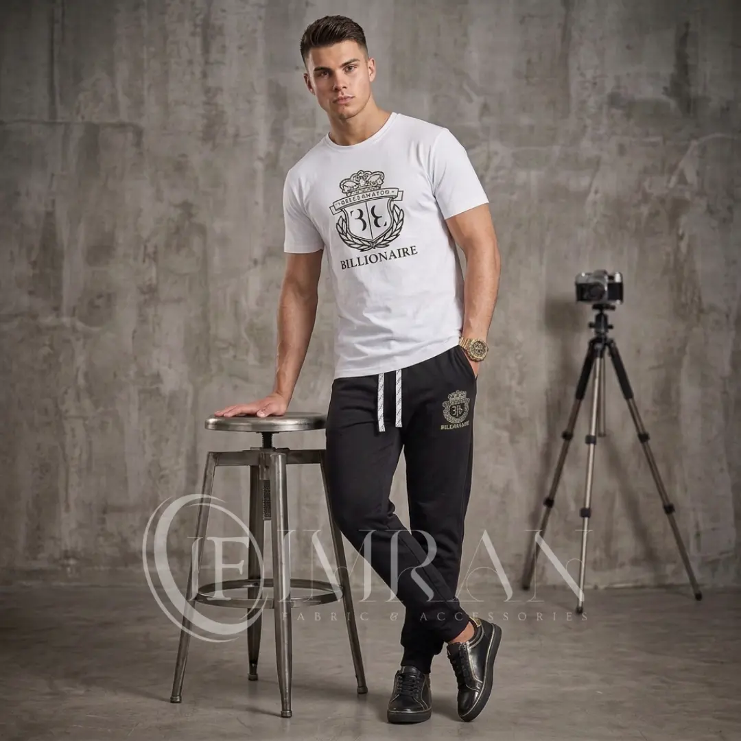 Model wearing Full 2-piece-billionaire-crest-edition-Tracksuit for men`s featuring a arctic-white-"Billionaire" graphic t-shirt and onyx black joggers in photo studio
