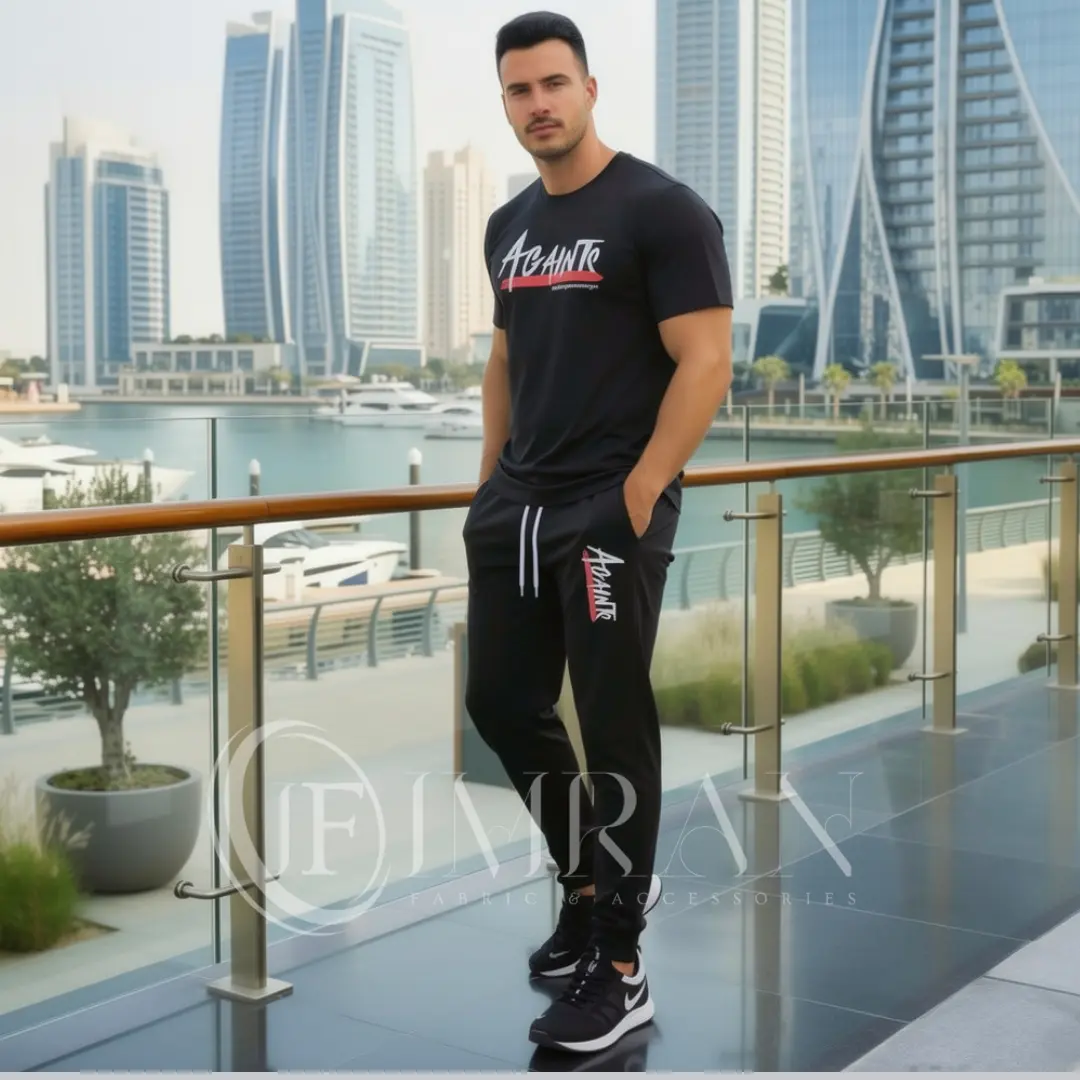 Model wearing Full 2-piece AGAINTS Urban Series Tracksuit fro men`s featuring a midnight-black"AGAINTS" graphic t-shirt and onyx black joggers on th roof top of skyline buliding
