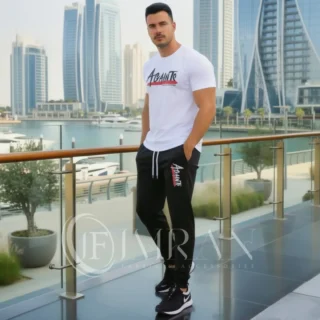 Model wearing Full 2-piece AGAINTS Urban Series Tracksuit for men`s featuring a arctic white "AGAINTS" graphic t-shirt and onyx black joggers on th roof top of skyline buliding